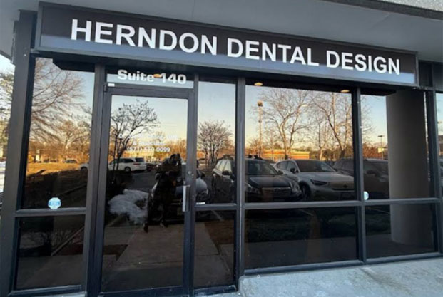 The image shows a storefront with a sign that reads Henderson Dental Design, indicating the name of the business located within the building.